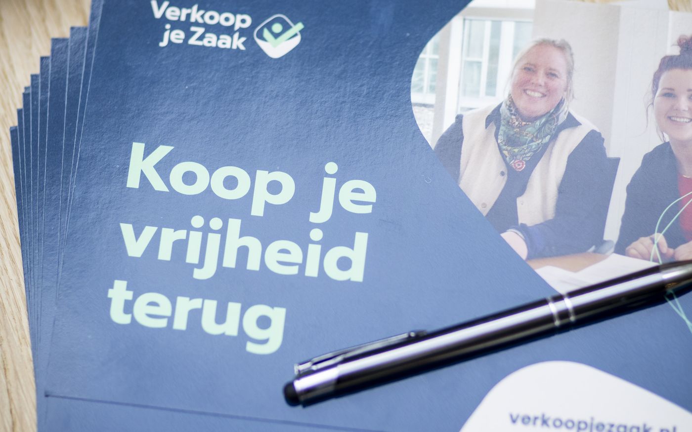 Het boek Built to Sell naast materiaal van Verkoop je Zaak op tafel