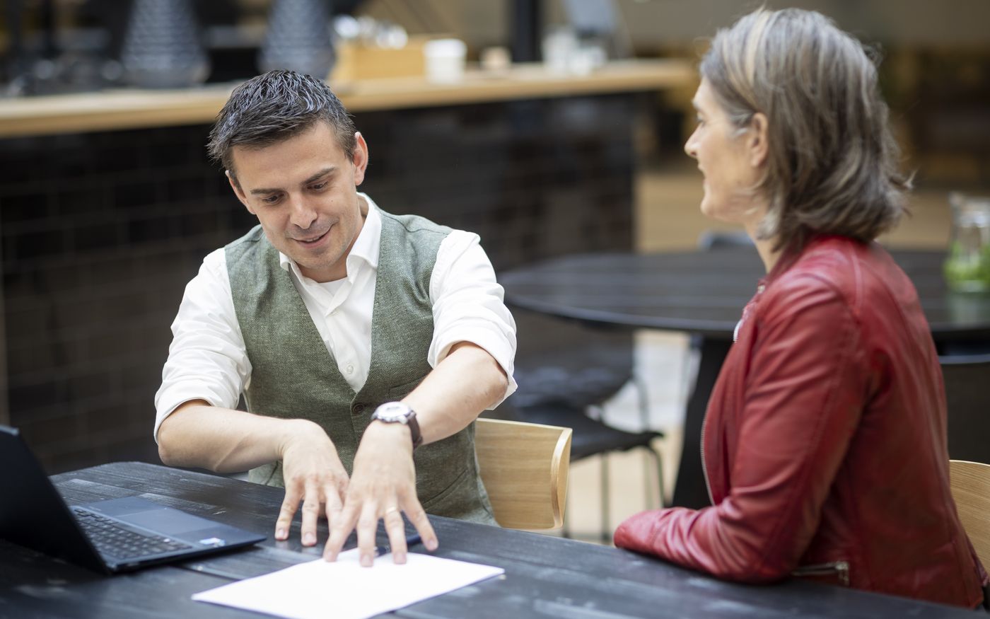 Adviseur en koper bespreken de earn-outafspraken aan de onderhandeltafel
