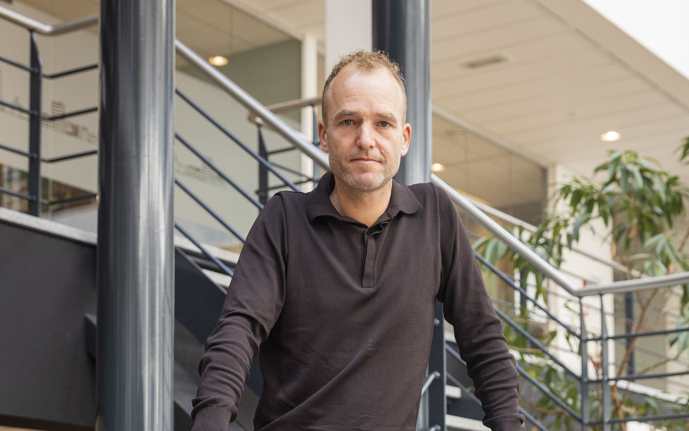 Ondernemer bij de trap, nadenkend over de eigen naam als bedrijfsnaam bij verkoop