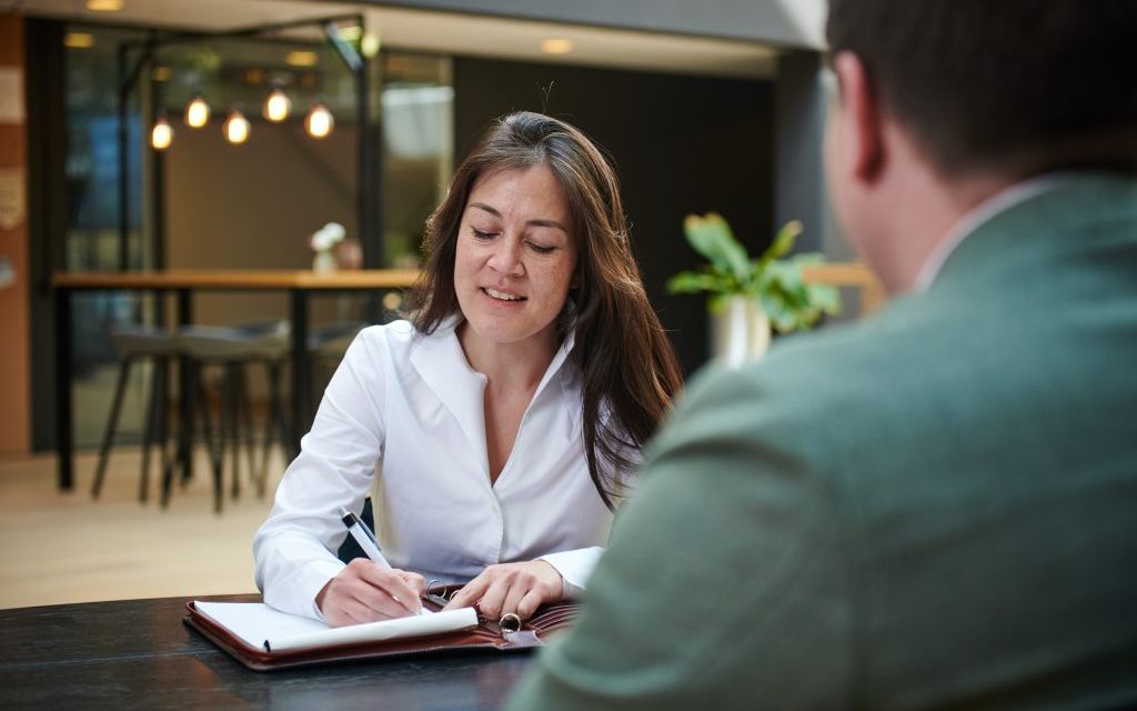 Ondernemer ondertekent het informatie memorandum aan tafel