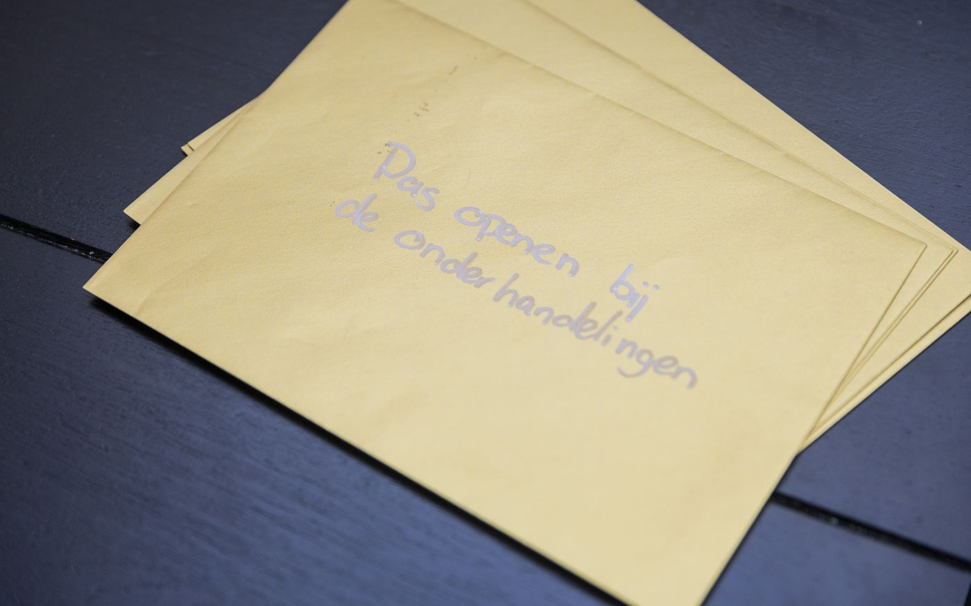 Verzegelde envelop met de tekst pas openen bij de onderhandelingen, symbool voor geheimhouding