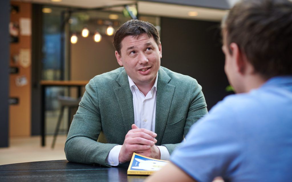 Adviseur en ondernemer bespreken achter de laptop de kosten van een SaaS-verkoop